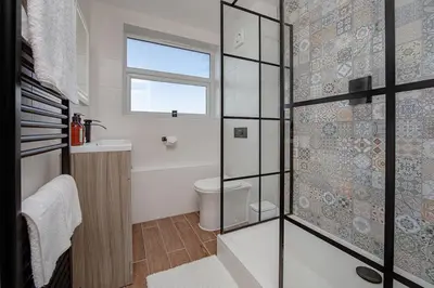 a bathroom with a toilet and a glass shower at Coastal Charm In Clacton On Sea in Holland-on-Sea