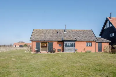 a red brick house with a large yard at The Meadows Dairy, Bawdsey in Bawdsey