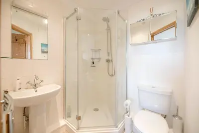 a bathroom with a shower and a toilet and a sink at The Meadows Dairy, Bawdsey in Bawdsey