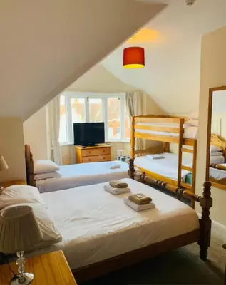 a bedroom with two bunk beds and a tv at The Cobham Hotel in Southend-on-Sea