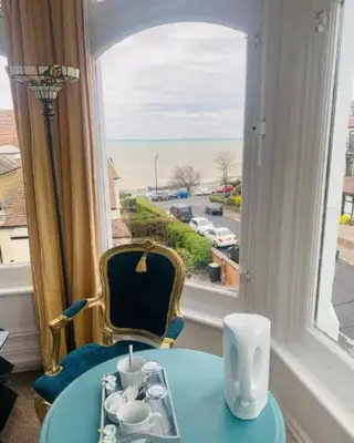 a table and a chair in a room with a window at The Cobham Hotel in Southend-on-Sea