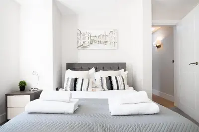 a white bedroom with a large bed with white pillows at Vineyard Style 2BR with Garden and Parking in Shudy Camps