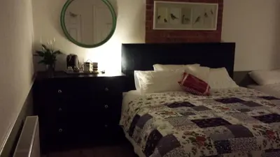a bedroom with a bed and a dresser and a mirror at The Railway Inn Westerfield in Ipswich