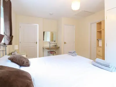 a bedroom with a large white bed with two pillows at Rookyard Cottage in Halesworth