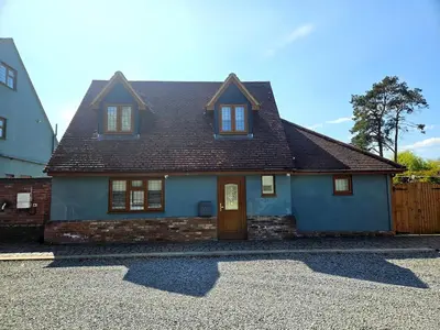 a blue house with a brown roof at Little George in Rayne