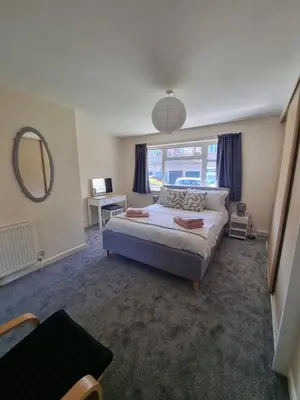 a bedroom with a bed and a large window at Blossom House in Woodbridge