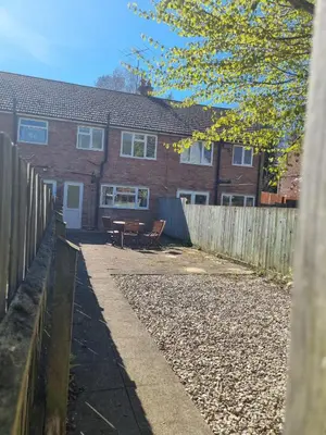a brick house with a fence and a patio at Blossom House in Woodbridge