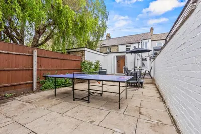 a ping pong table in the backyard of a house at Cozy accessible 2bd flat on Mill road with firepit for a lovely winters night in Cambridge