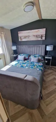 a bedroom with a large bed with two pillows at The Beach House East Mersea in Mersea Island