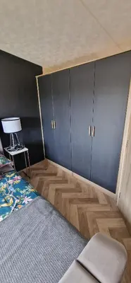 a bedroom with a bed and a wall of cabinets at The Beach House East Mersea in Mersea Island