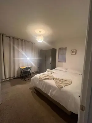 a bedroom with a bed and a table in it at Golden House in Waterbeach