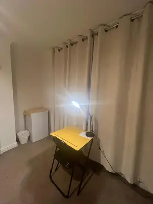 a room with a desk with a light on a curtain at Golden House in Waterbeach