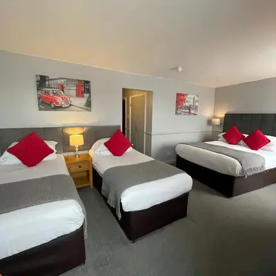 a hotel room with two beds with red pillows at The White Hart Hotel Witham in Witham