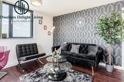 a living room with a black couch and a table at Penthouse Panoramic 2 Bedroom -Basildon Essex in Laindon