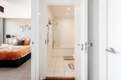 a bedroom with a bed and a bath tub at Penthouse Panoramic 2 Bedroom -Basildon Essex in Laindon