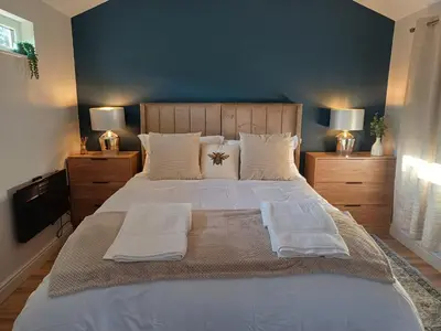 a bedroom with a large bed with white sheets and pillows at The Beehive Inn in Bury Saint Edmunds
