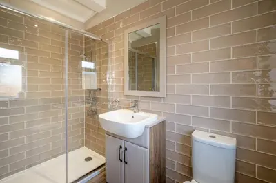 a bathroom with a sink and a toilet and a shower at Driftwood Lodge, Sizewell - Adults only property - Aldeburgh Coastal Cottages in Sizewell
