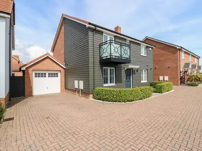 a house with a balcony on top of a driveway at 21 Skippers Way in Walton-on-the-Naze