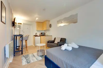 a small bedroom with a bed and a kitchen at Pass the Keys Stylish and modern apartment in Cambridge