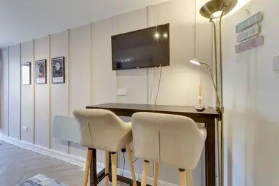a room with a table and two chairs and a television at Pass the Keys Stylish and modern apartment in Cambridge
