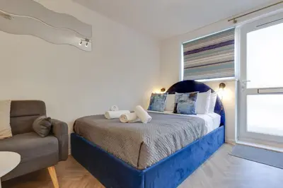 a bedroom with a bed and a chair and a window at Pass the Keys Stylish and modern apartment in Cambridge