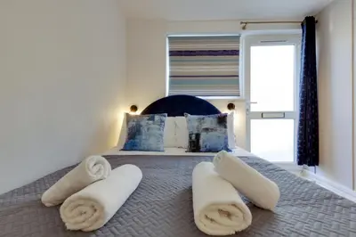 a bedroom with a bed with towels on it at Pass the Keys Stylish and modern apartment in Cambridge