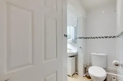 a white bathroom with a toilet and a sink at Pass the Keys Stylish and modern apartment in Cambridge
