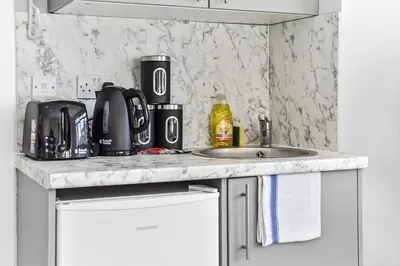 a kitchen counter with a sink and a microwave at Studio Society - Stay, Cook, and Connect in Southend-on-Sea