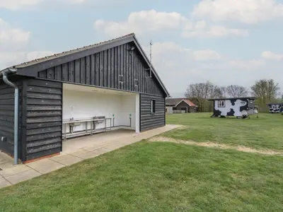 a large black barn with a large garage at Betsy Cow Shed 2 in Woodbridge