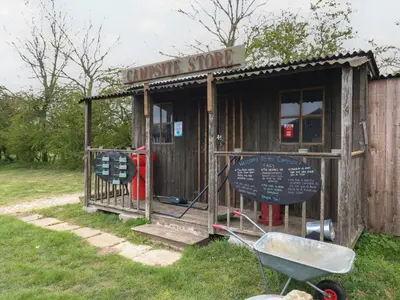 a small wooden shack with a sign on it at Dozy Dotty Cow Shed 4 in Woodbridge