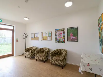 a waiting room with chairs and posters on the wall at Daisy Cow Shed 1 in Woodbridge