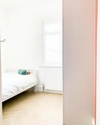 a white room with a bed and a mirror at Relaxing home Leigh on Sea in Southend-on-Sea