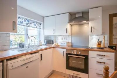 a kitchen with white cabinets and an oven at Stable Cottage, Friston in Friston