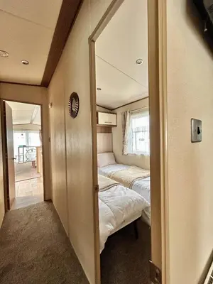 a small room with two beds and a mirror at VerbLake 5 Berth Caravan St Osyth Beach Holiday Park in Saint Osyth