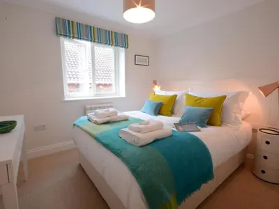 a bedroom with a large bed with towels on it at Sea Crest in Aldeburgh