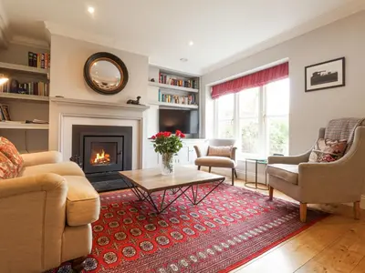 a living room with a fireplace and a table at Sea Crest in Aldeburgh
