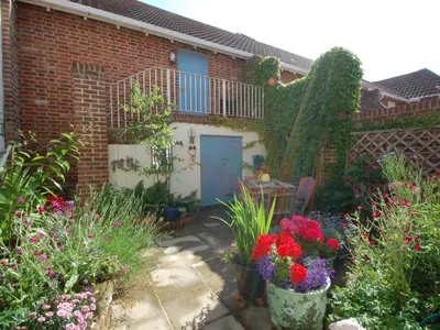a garden with flowers in front of a house at Sea Crest in Aldeburgh
