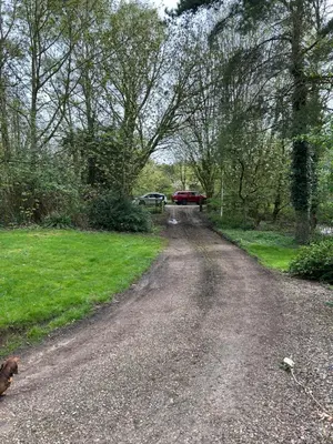 a dirt road with a dog on the side at Giffords Hall Garden Room in Shimpling