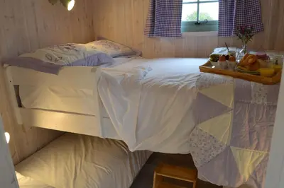 a bedroom with a bed with a tray of fruit on it at Shepherds Hut 6 in Bedfield