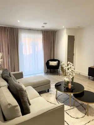 a living room with a couch and a table at TT Maison in Brentwood