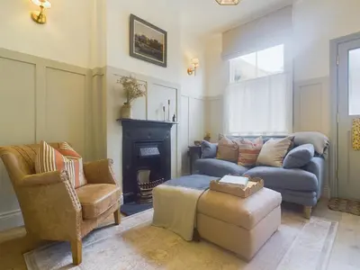 a living room with a couch and a chair at Stunning Heritage Cottage- The Heart of Old Leigh in Southend-on-Sea