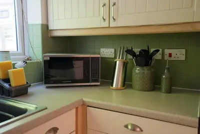 a kitchen counter with a microwave and some utensils at Spacious 5 Bedrooms Sleeps 9 3 Bath and Parking Ideal for Contractors in Chesfield