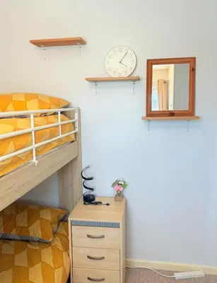 a bedroom with a bunk bed and a clock on the wall at Heartfelt Cambridge Home in Cottenham