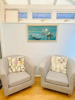 two chairs in a living room with a picture on the wall at Heartfelt Cambridge Home in Cottenham
