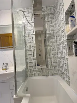 a white bathroom with a tub and a sink at Lighthouse Lodge in Harwich
