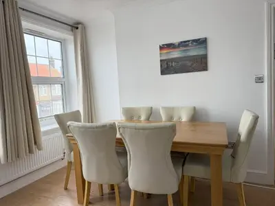 a dining room with a wooden table and chairs at Lighthouse Lodge in Harwich