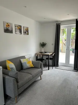 a living room with a couch and a table at The Annexe Long Melford in Long Melford