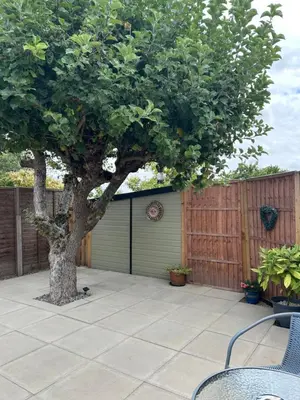 a patio with a tree and a garage at The Annexe Long Melford in Long Melford
