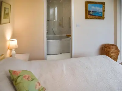 a bedroom with a bed and a bathroom with a tub at Swallowdale in Flordon