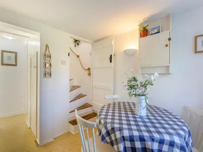 a room with a table with a vase of flowers on it at Island Cottage in West Mersea